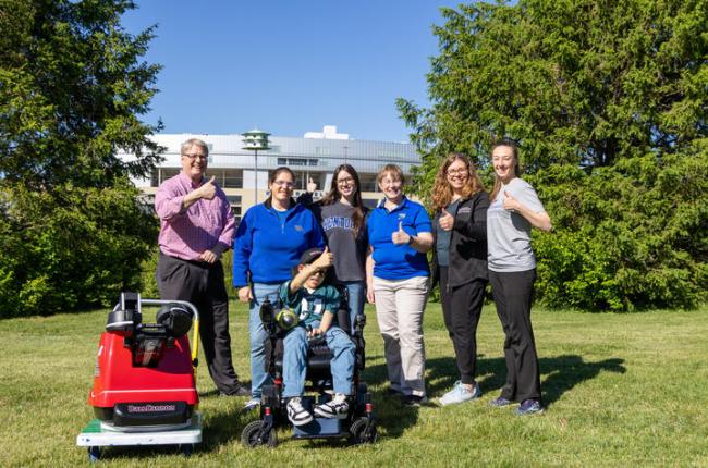 Sam Roberts with members of his care team and UK Pigman College of Engineering student Audra Proffitt, who helped design his custom football-throwing device.